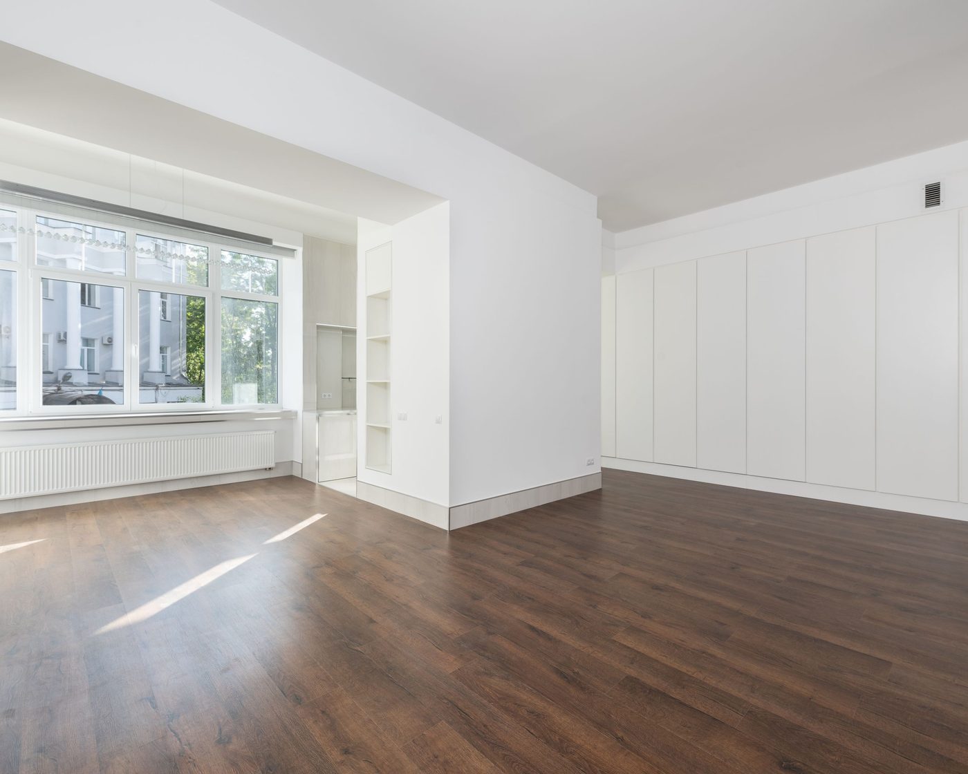 An empty room with clean floors, ready for the new residents